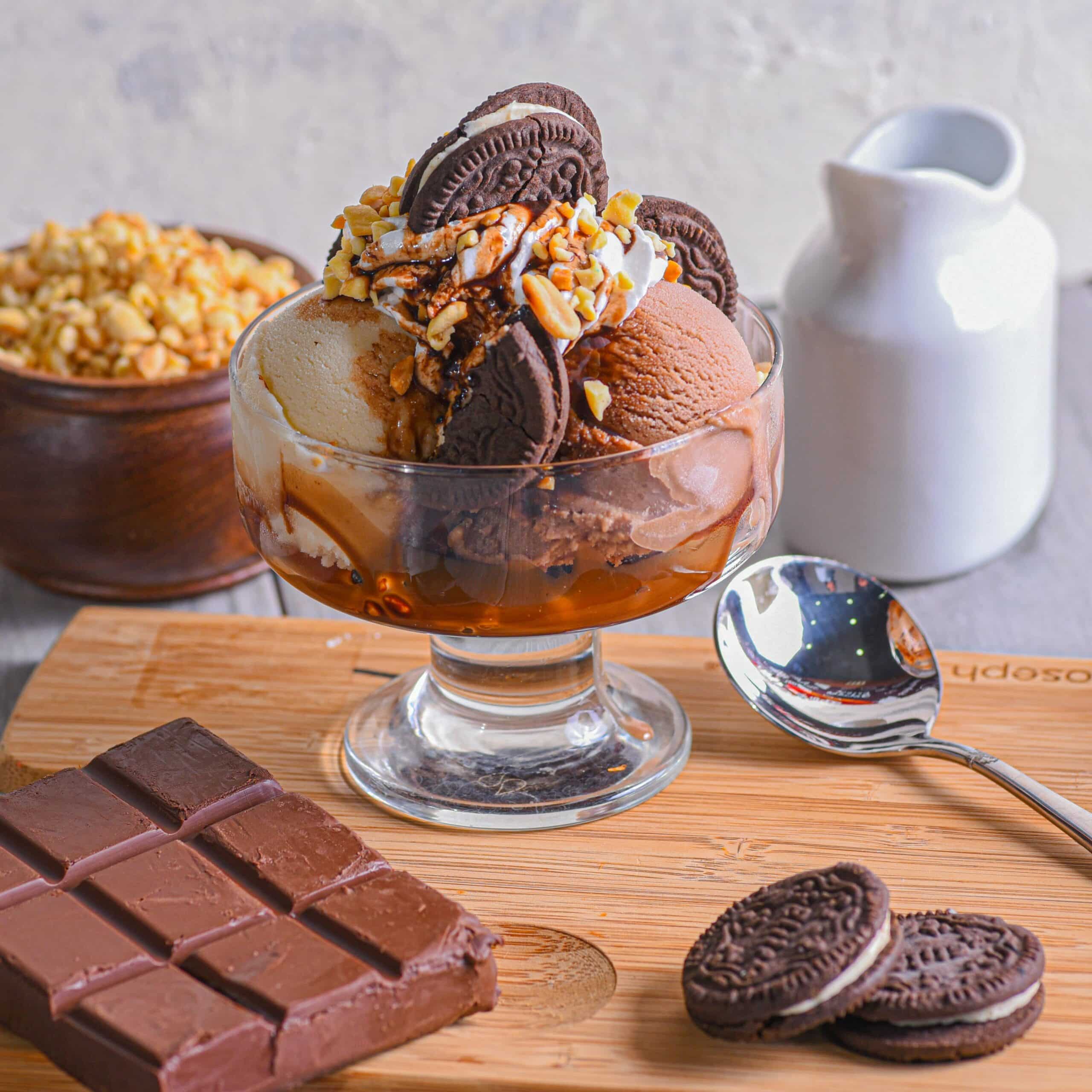 Indulgent chocolate ice cream sundae with cookies, nuts, and syrup, perfect for dessert lovers.