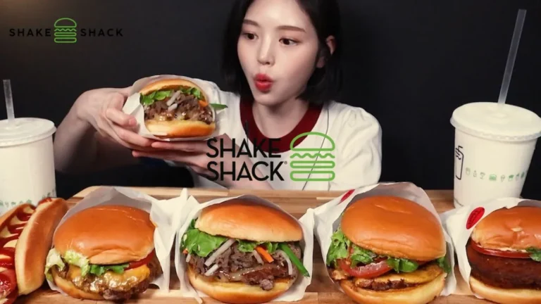 The Korean-Style Menu is back at Shake Shack as a young woman reacts to multiple burgers with juicy beef patties and fresh toppings.