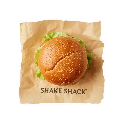 Shake Shack cheeseburger wrapped in branded paper with sesame seed bun, lettuce visible - authentic fast-casual burger presentation