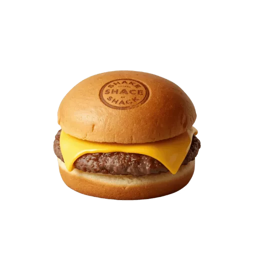 Shake Shack single cheeseburger side view with Angus beef patty, melted American cheese on branded potato bun - classic ShackBurger profile shot