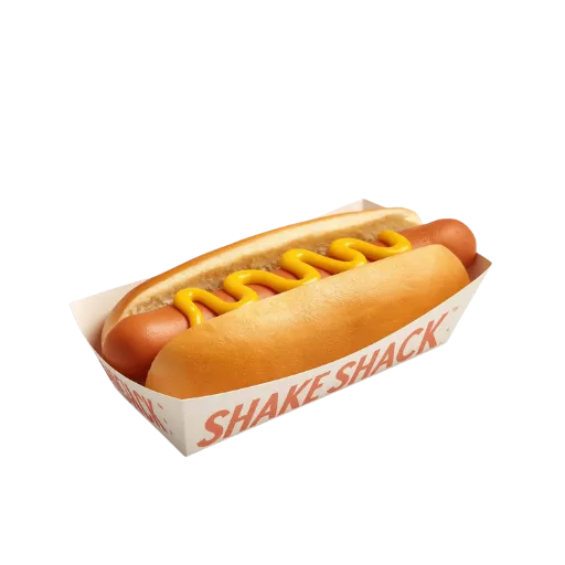 A classic Shake Shack beef hot dog topped with a signature swirl of yellow mustard, served in a branded Shake Shack paper tray on a toasted potato bun