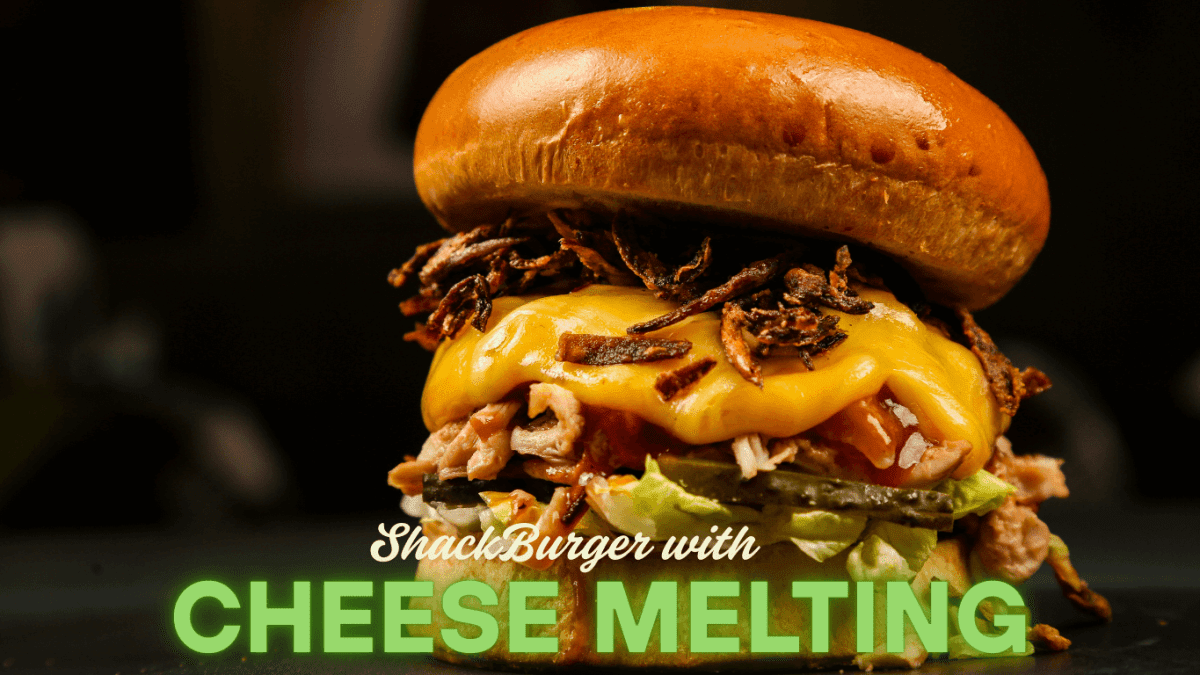 Close-up of a juicy ShackBurger with melted cheese, lettuce, and tomato.